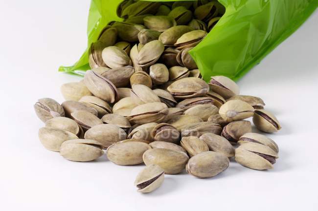Pistachios falling from plastic bag — Stock Photo