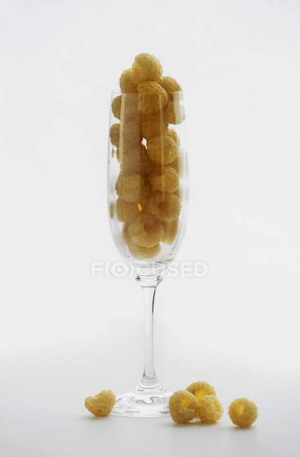 Framboesas douradas em vidro — Fotografia de Stock