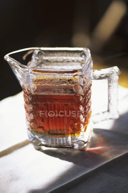 Closeup view of maple syrup in a glass pitcher — Stock Photo