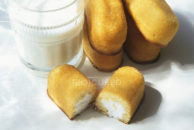 Twinkies con un vaso de leche - foto de stock