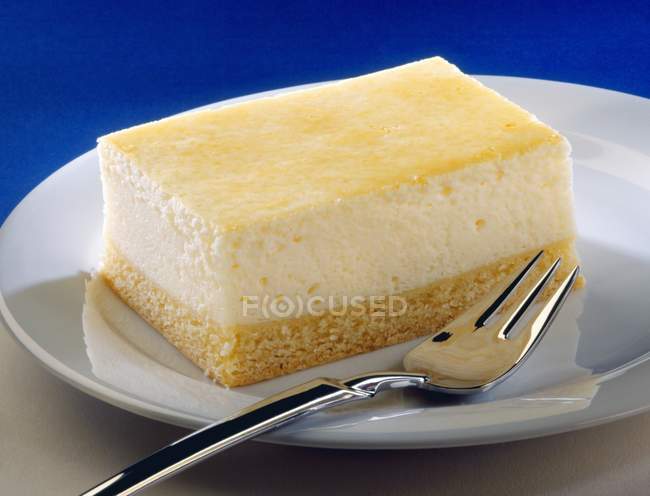 Tarta de queso rebanada en el plato con tenedor - foto de stock