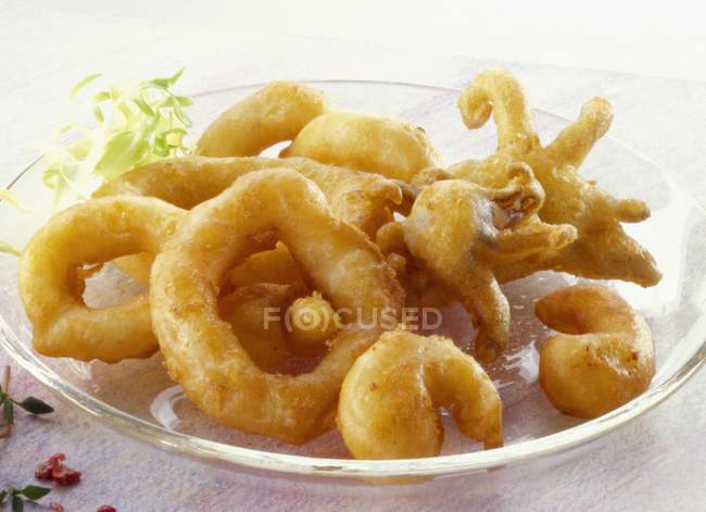 Closeup view of deep-fried squid pieces with herb — Stock Photo