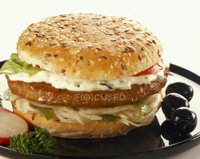 Hamburger with sauce and olives — Stock Photo