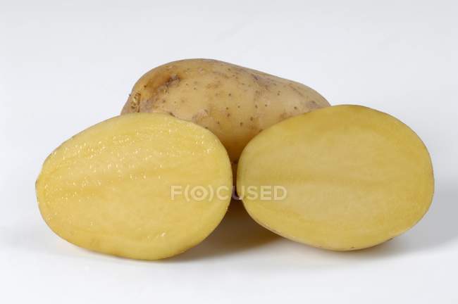 Ganze Kartoffel und zwei Kartoffelhälften — Stockfoto