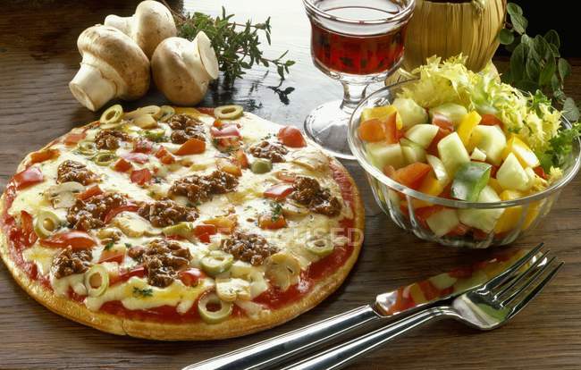 Pizza con verduras en la mesa - foto de stock