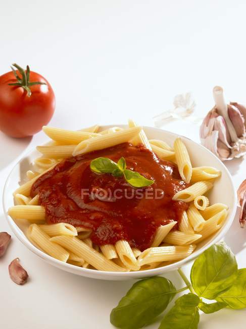 Pasta de penne con salsa de tomate y albahaca - foto de stock
