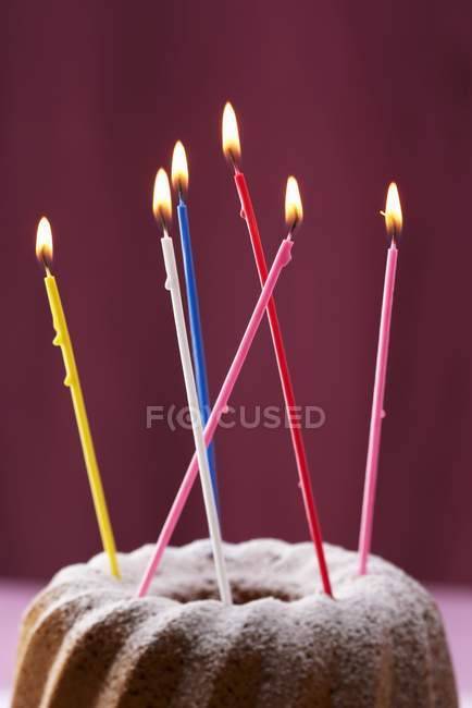 Vista de primer plano de Gugelhupf con velas de cumpleaños de colores - foto de stock