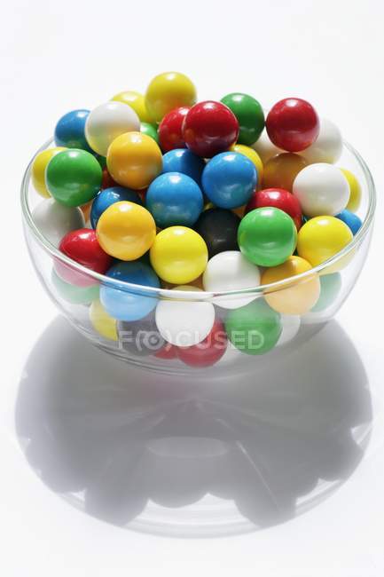 Vista close-up de bolas de goma de mascar coloridas em tigela de vidro — Fotografia de Stock