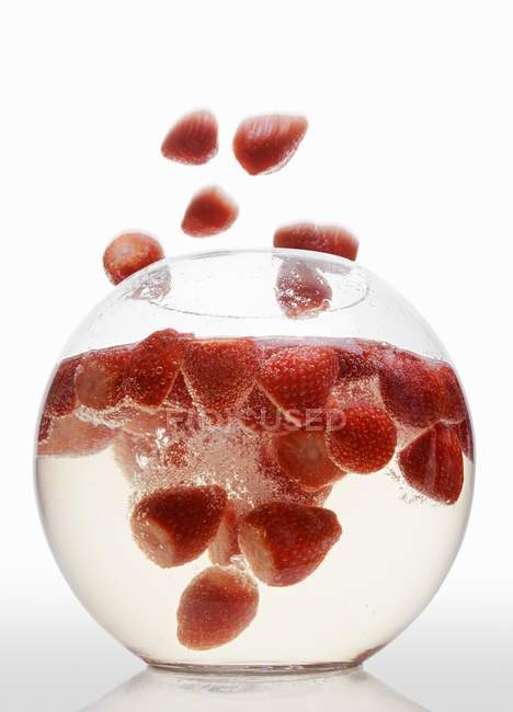 Erdbeeren fallen in Glasschale — Stockfoto