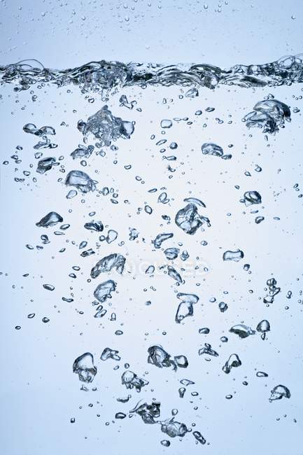 Vue rapprochée des bulles d'air montant dans l'eau — Photo de stock