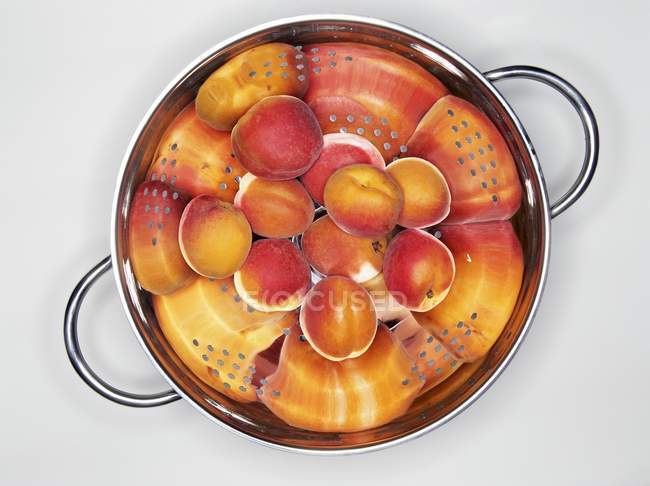 Frische reife Aprikosen im Sieb — Stockfoto