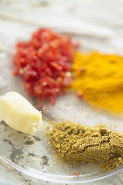 Especias e ingredientes para el curry de garbanzos en plato de vidrio - foto de stock