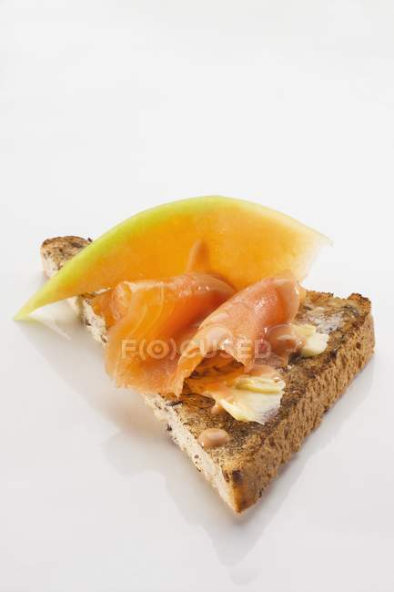 Toast triangle with salmon and melon — Stock Photo