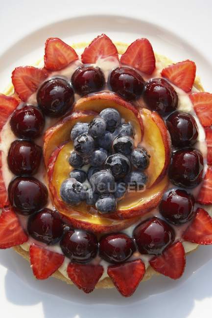 Gros plan vue du dessus du fruit Gateau aux myrtilles, cerises, fraises et pommes — Photo de stock