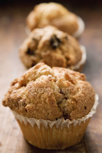 Assorted muffins on wooden surface — Stock Photo