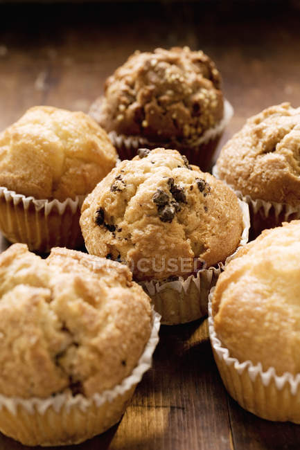 Muffins sortidos na superfície de madeira — Fotografia de Stock