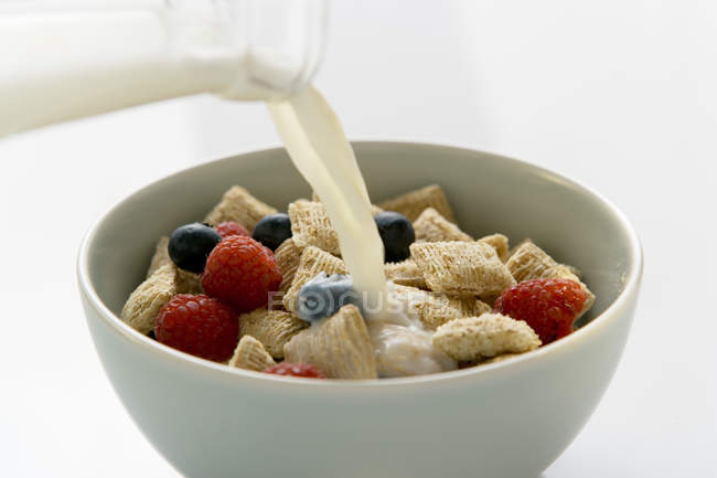 Verter leche sobre los cereales - foto de stock