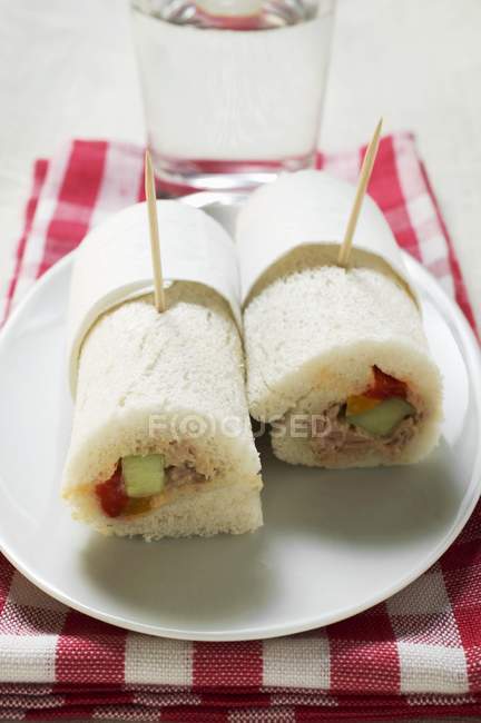 Deux rouleaux de tramezzini de thon sur une assiette blanche sur une serviette — Photo de stock
