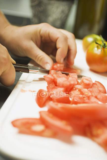 Menschenhände schneiden Tomaten — Stockfoto