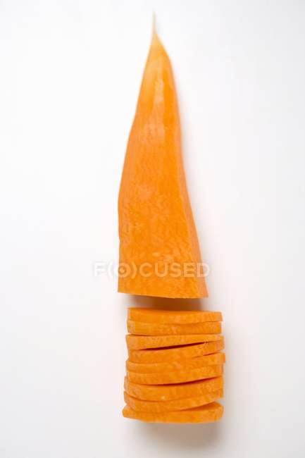 Cenoura parcialmente cortada em pedaços descascada — Fotografia de Stock