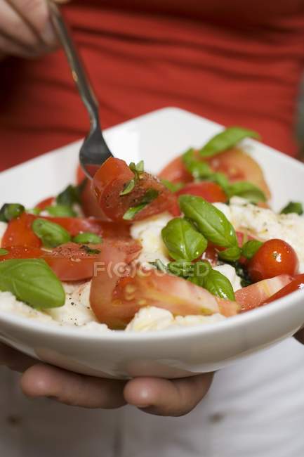 Donna che mangia pomodori con mozzarella — Foto stock