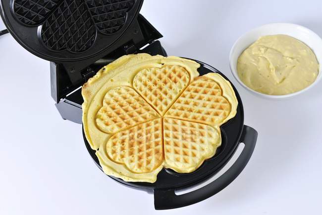 Waffles in a waffle iron — Stock Photo
