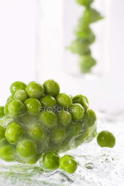 Frozen peas in block of ice — Stock Photo