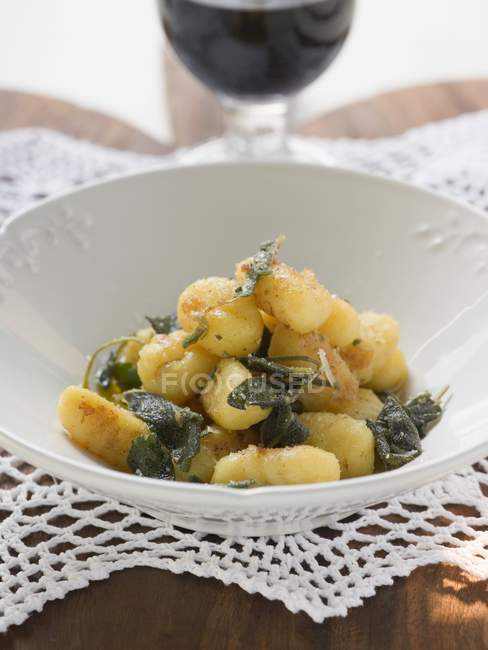 Closeup view of Gnocchi with sage in white bowl — Stock Photo