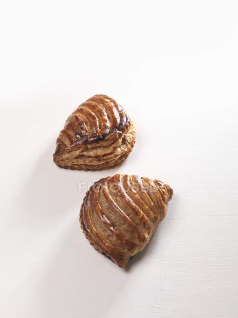 Closeup view of two apple baked turnovers on white background — Stock Photo