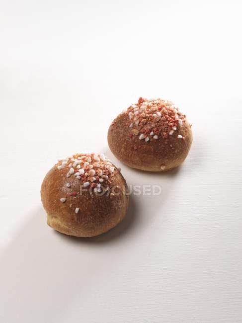 Closeup view of two Brioches with sugared almonds on white surface — Stock Photo