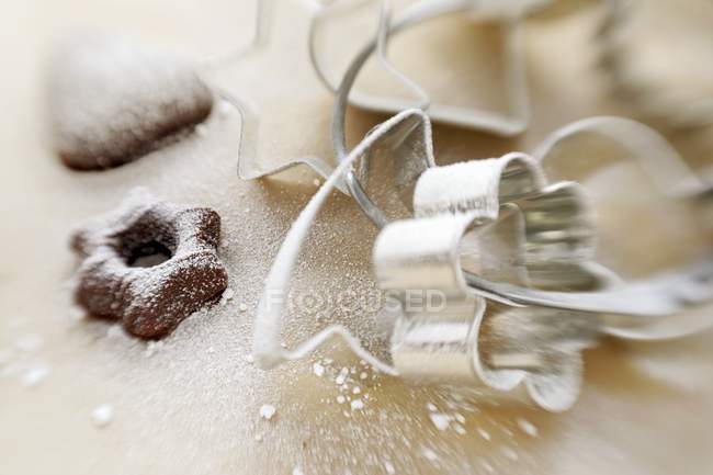 Vue rapprochée de découpeuses de biscuits et biscuits assortis avec sucre glace — Photo de stock