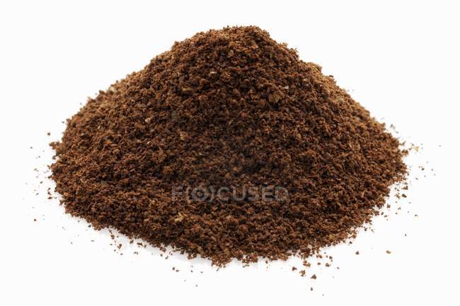 Closeup view of a heap of ground coffee on white surface — Stock Photo