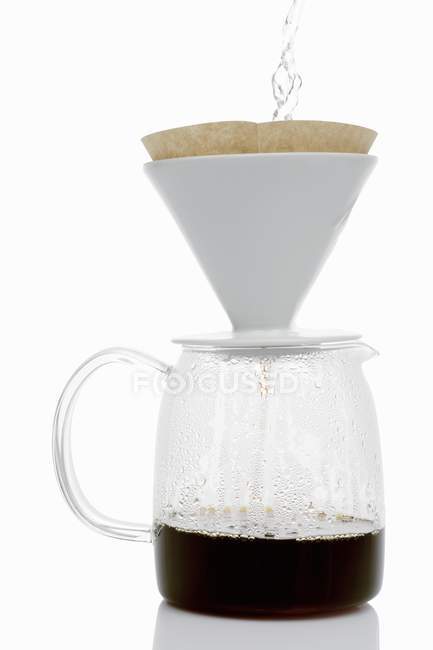 Versando acqua calda sul filtro del caffè — Foto stock