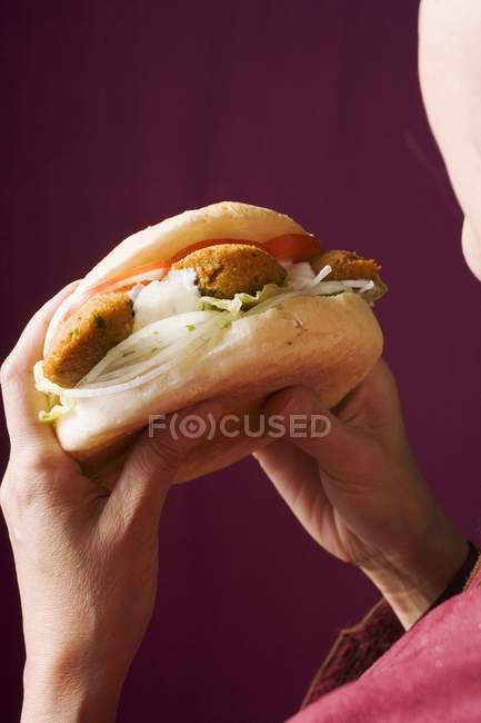 Hands holding flatbread filled with falafel — Stock Photo