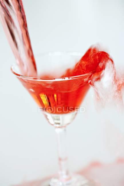 Martini rojo se vierte en un vaso - foto de stock