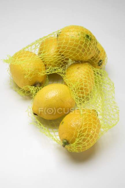 Ripe Lemons in net — Stock Photo