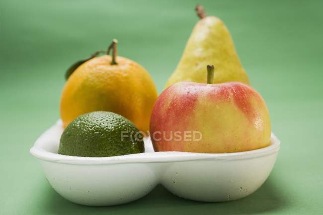 Lima y manzana en bandeja de poliestireno - foto de stock