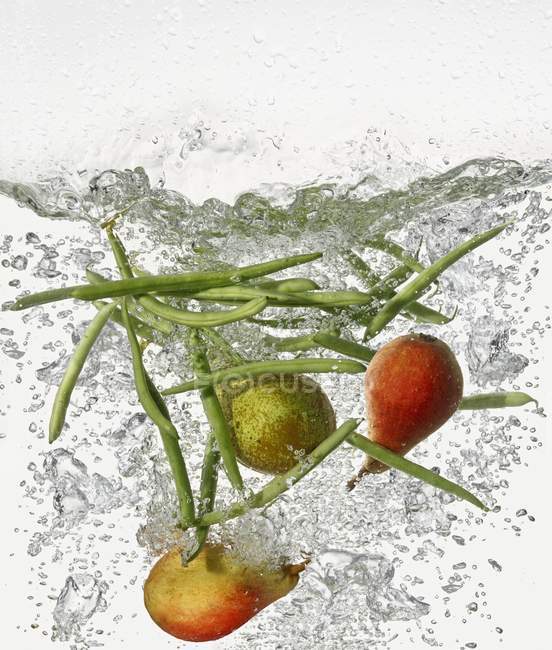 Груши и бобы в кипящей воде — стоковое фото