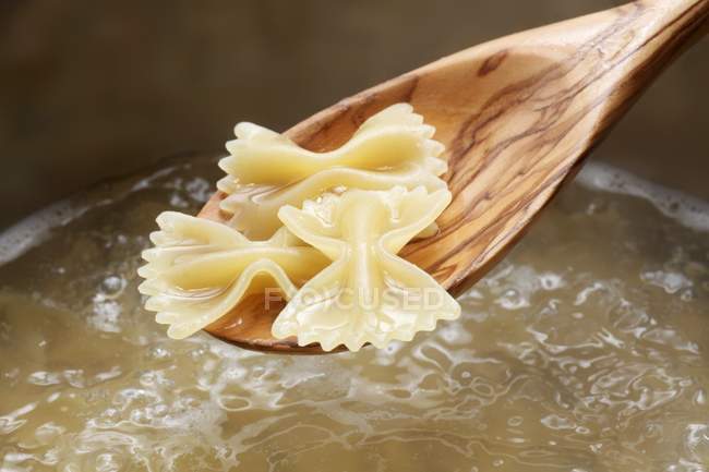 Farfalle pasta on wooden spoon — Stock Photo