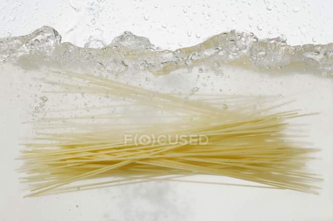 Espaguetis en agua hirviendo - foto de stock