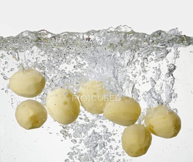 Peeled potatoes in boiling water — Stock Photo