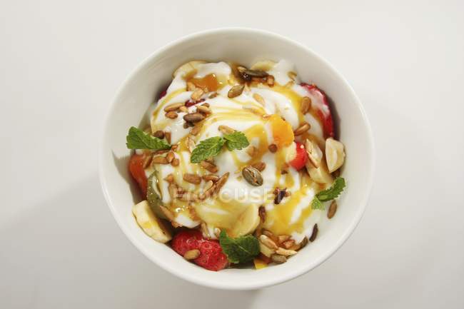 Фруктовий салат з йогуртом та кедровими горіхами — стокове фото