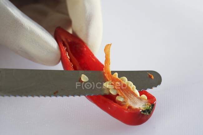 Human hand deseeding out of pepper — Stock Photo