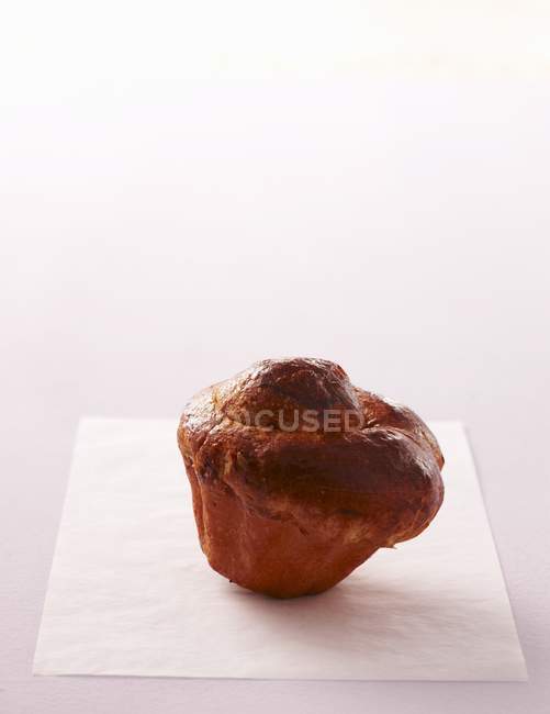 Closeup view of one Brioche on piece of paper — Stock Photo
