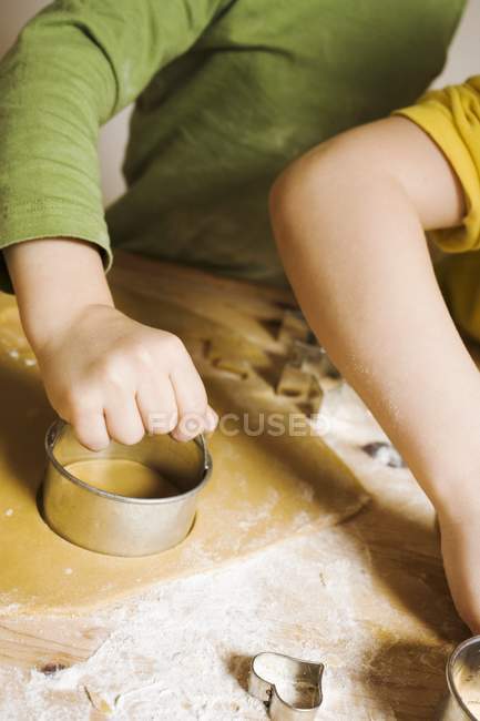 Cropped view of children cutting out biscuits — Stock Photo