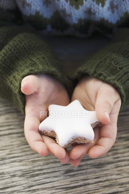 Vista cortada de mãos segurando biscoito em forma de estrela — Fotografia de Stock