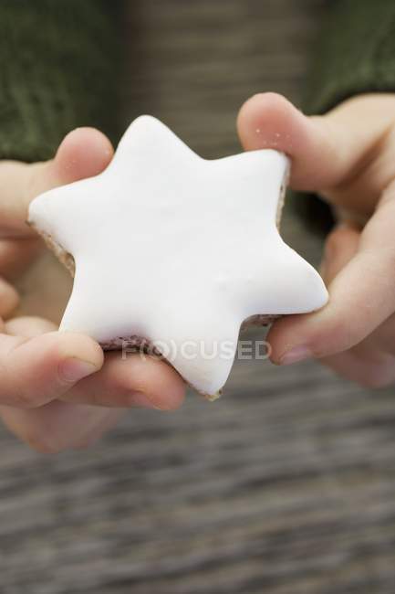 Closeup cropped view of hands holding cinnamon star — Stock Photo