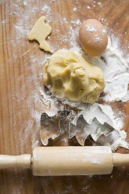 Dough, biscuit cutters and rolling pin — Stock Photo
