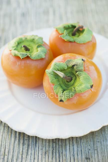 Frutas frescas de Sharon no prato — Fotografia de Stock