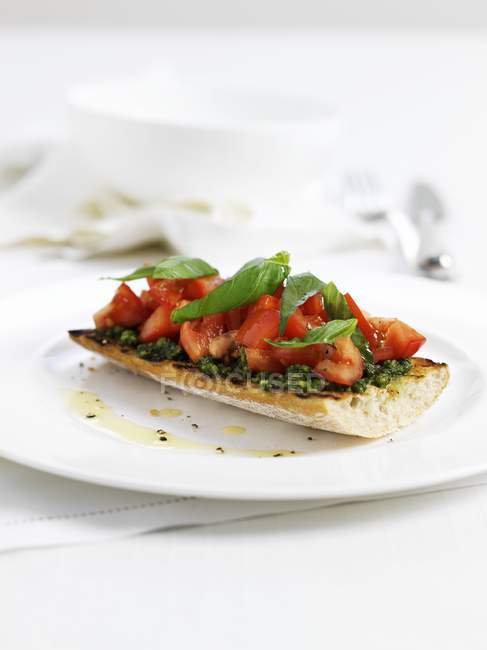 Bruschetta with tomato and basil on white plate — Stock Photo